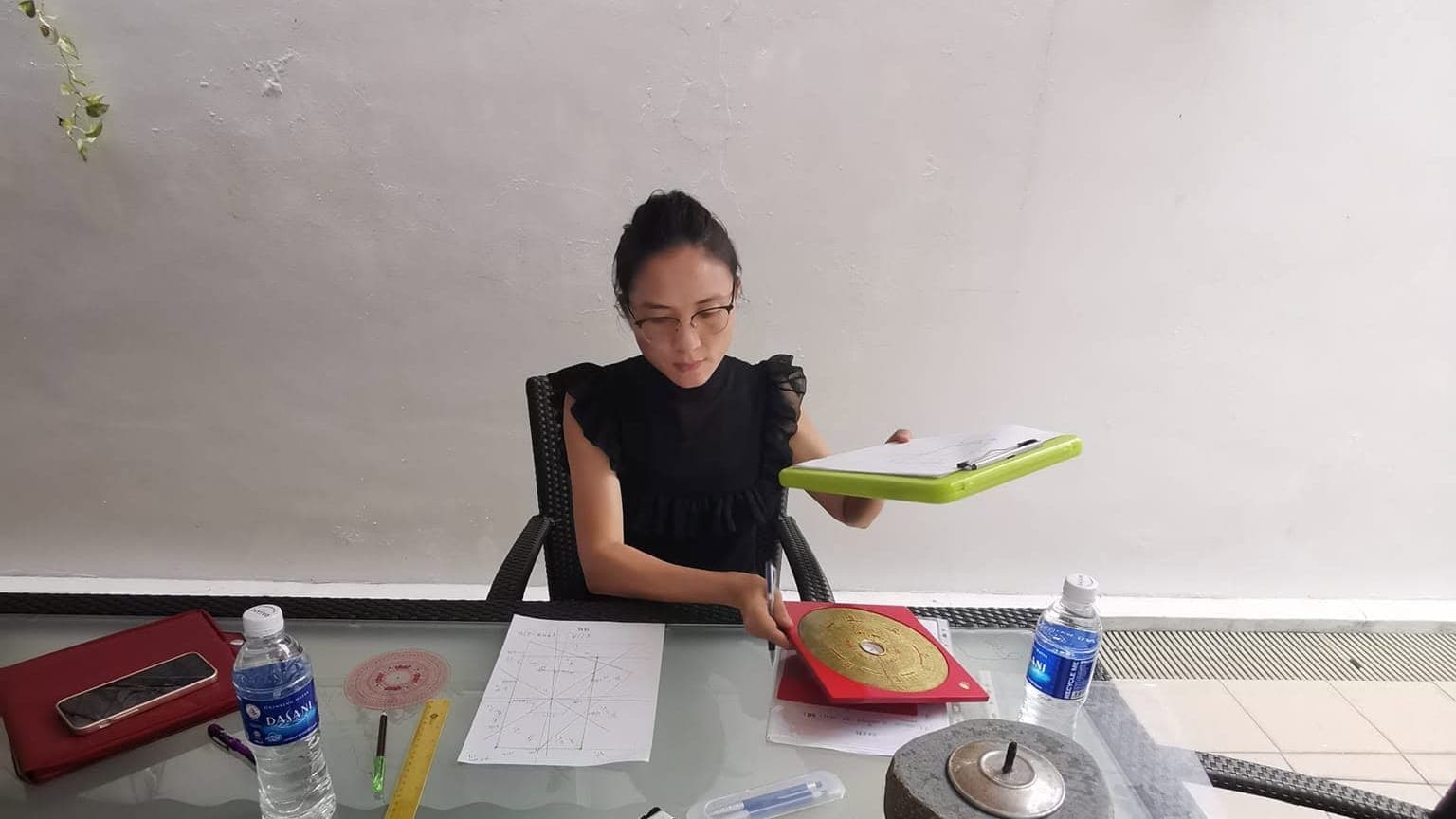 Jessica taking compass readings in a Singapore flat during a feng shui assessment
