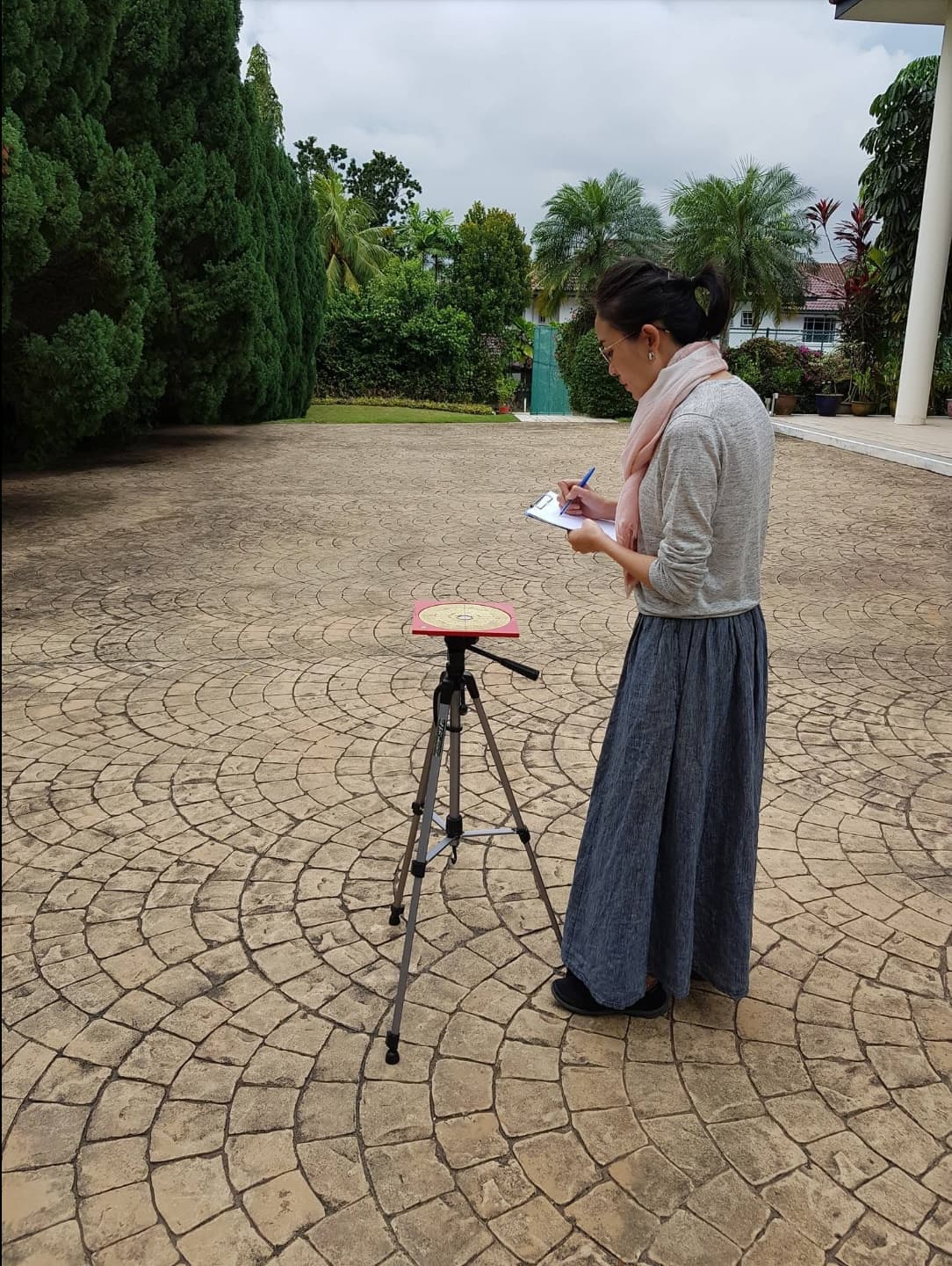 Jessica taking compass readings during a residential feng shui assessment in Singapore