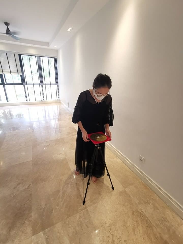 Jessica taking a compass reading with a luo pan on a tripod in an empty flat